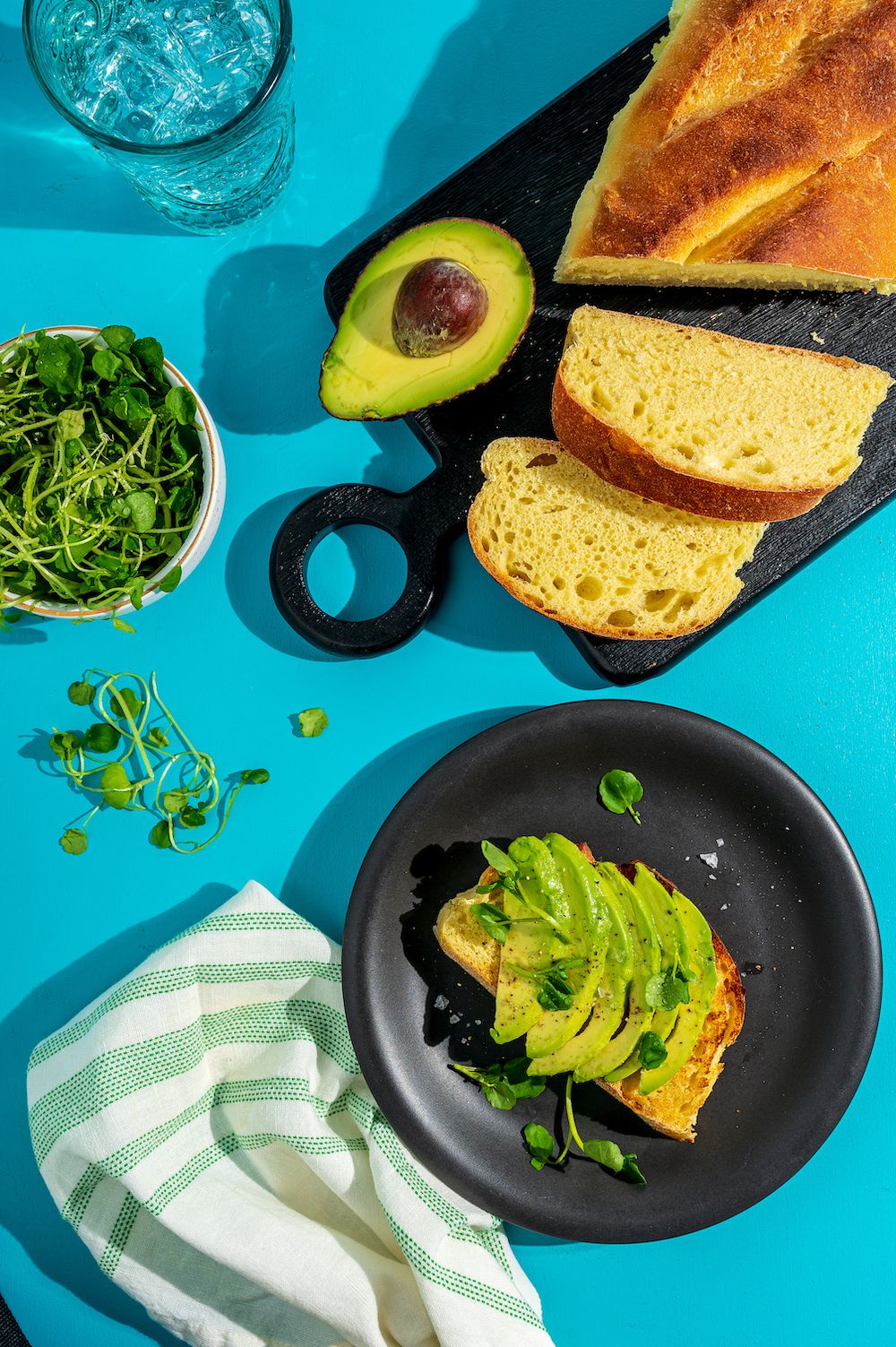 Avocado toast and bread on a bright board