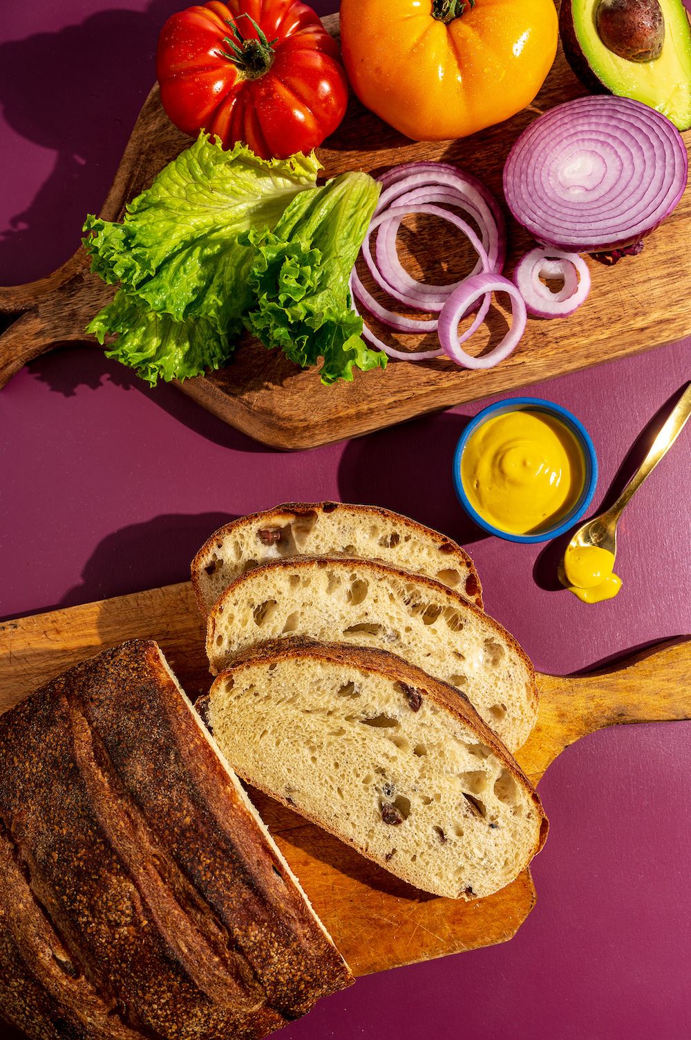 Sliced bread on a board with fresh vegetables