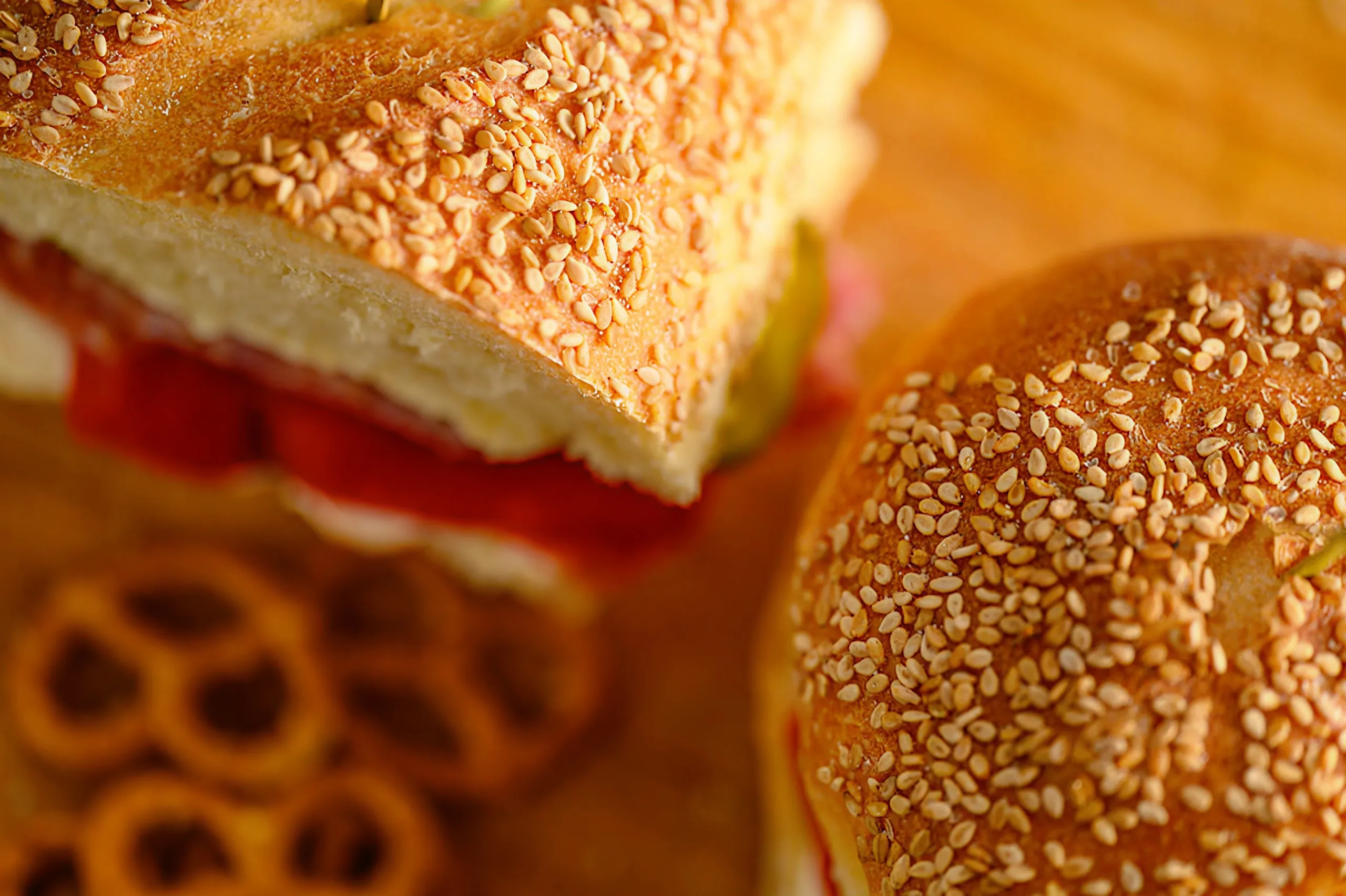 Sesame-crusted Italian bread and a sandwich on a wooden board